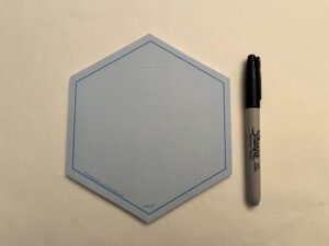 A BLUE VIS-IT™ Hexagon Pad 6x6 in. (50 sheets) with a marker on it.