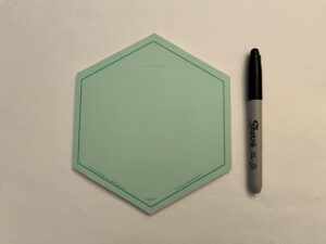 The GREEN VIS-IT™ Hexagon Pad 6x6 in. (50 sheets) with a marker on it.