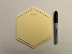 A yellow WHITE VIS-IT™ Hexagon Pad 6x6 in. (50 sheets) with a marker next to it.